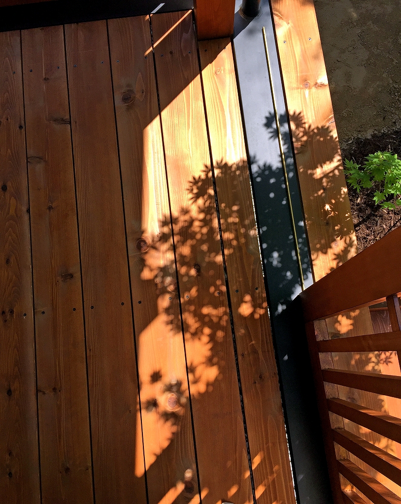 宝塚の木の家ウッドでデッキに映るモミジの影.jpg
