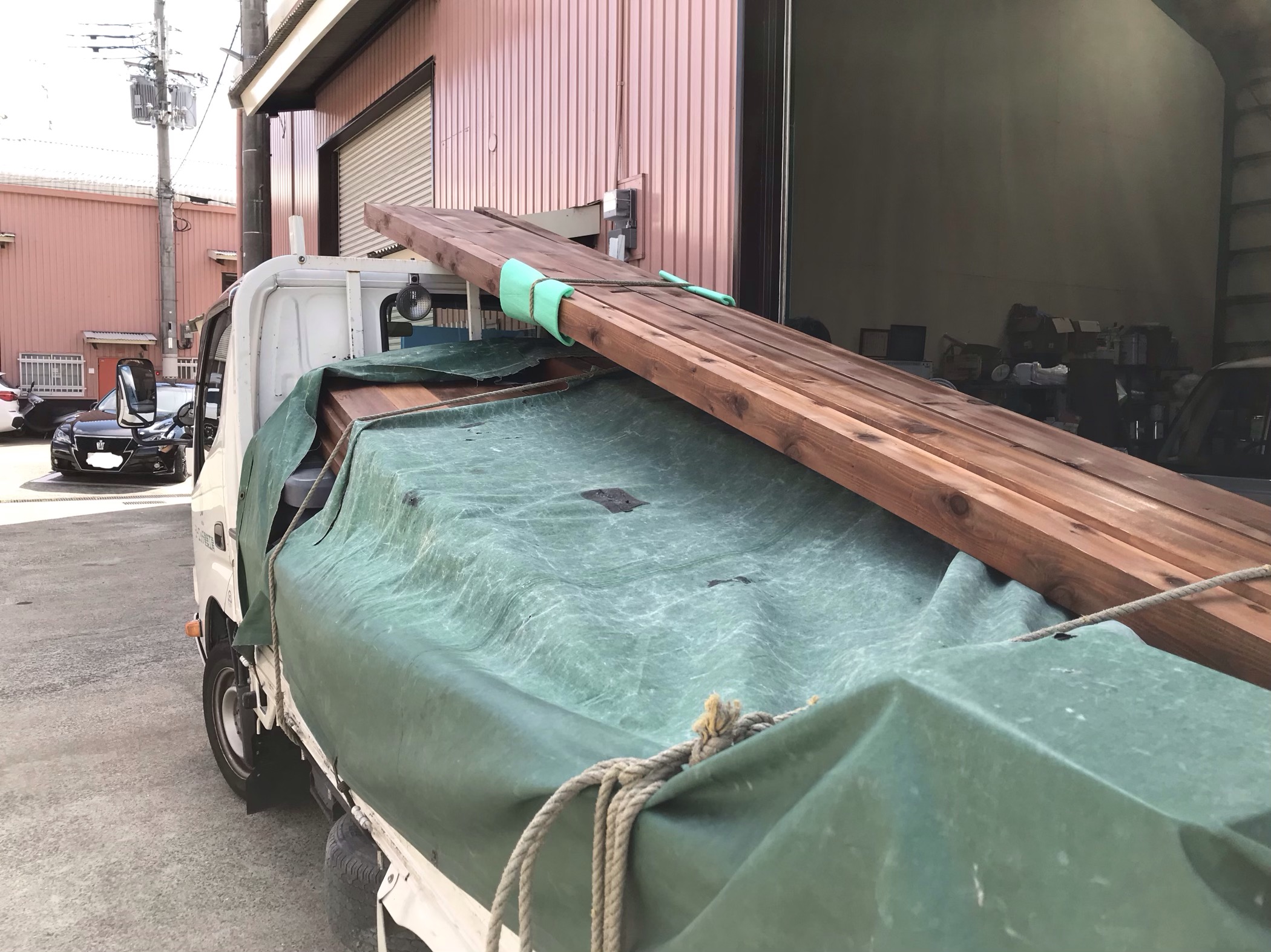 宝塚市シーエッチ建築工房のトラックにウッドデッキの材料が積んであります。